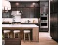 Modern kitchen featuring dark cabinets, stainless steel appliances, and a center island with seating at 7043 Foundry Dr, Woodstock, GA 30188