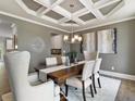 Elegant dining room features coffered ceiling, chandelier, and modern furniture on hardwood floors at 3710 Near Star Ln, Cumming, GA 30028