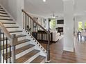 Inviting entryway with wood stairs, iron railings, hardwood floors and view into the living room at 3710 Near Star Ln, Cumming, GA 30028