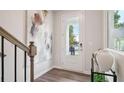 Bright foyer with a glass-paneled door, wood-look floors, modern art, and views of greenery outside at 111 Chestnut Trce # 9, Hapeville, GA 30354