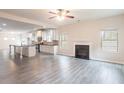 Open concept living room and kitchen with hardwood floors, fireplace, and a large island at 3443 Woodshade Dr, Loganville, GA 30052