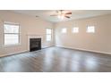 Bright living room features a fireplace, three windows, and hardwood floors at 3443 Woodshade Dr, Loganville, GA 30052