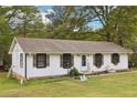 Side view of a charming one-story home on a large lawn with flower boxes at 419 Fincher Rd, Covington, GA 30016