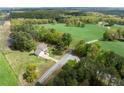 An aerial view of the home showing its secluded location surrounded by lush greenery and open fields at 190 Ccc Rd, Kingston, GA 30145