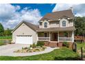 A two-story home with an attached garage, a welcoming front porch, and a beautifully landscaped front yard at 190 Ccc Rd, Kingston, GA 30145