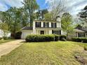 Charming two-story home featuring black shutters, a chimney, manicured bushes and a one-car garage at 3150 Berkshire Manor Dr, Alpharetta, GA 30022