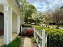 View of the front porch with red and pink flowers, green bushes, and a white picket fence at 3150 Berkshire Manor Dr, Alpharetta, GA 30022