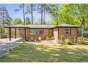 Well-kept brick home with a covered entrance, manicured lawn, and inviting front yard seating area at 3385 Pinehill Dr, Decatur, GA 30032