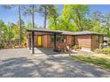 Inviting brick home featuring a covered entrance, gravel driveway, and cozy seating area on the front porch at 3385 Pinehill Dr, Decatur, GA 30032