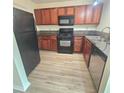 Well-lit kitchen features wood cabinets, black appliances, and granite countertops at 1557 Springleaf Se Ct, Smyrna, GA 30080