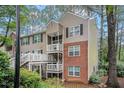 Exterior view of a two-story condo building with brick and siding, featuring outdoor stairs and landscaping at 306 Teal Ct, Roswell, GA 30076