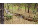 The backyard features a view of the creek with trees on either side at 540 Basil Sw Ct, Marietta, GA 30064