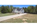 Exterior side view showcasing a well-maintained lawn, long driveway, and a charming two-story home at 95 Hawthorn Ln, Covington, GA 30014