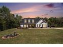 Charming two-story home with manicured lawn and classic white facade, showcased under a beautiful sunset sky at 95 Hawthorn Ln, Covington, GA 30014