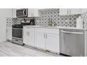 Modern kitchen with stainless steel appliances, white cabinets, and stylish backsplash at 215 Piedmont Ne Ave # 708, Atlanta, GA 30308
