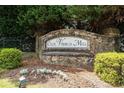 Stone community sign that marks the entrance to Olde Vinings Mill surrounded by green shrubs at 4062 Vinings Mill Se Trl, Smyrna, GA 30080