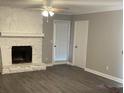 Cozy living room with a white stone fireplace, ceiling fan, and door to the exterior at 5516 Westberry Ln, Norcross, GA 30071