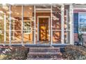 View of brick porch with brick steps, screen windows, and wooden front door at 948 Sycamore Dr, Decatur, GA 30030