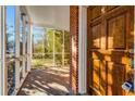 View from porch to yard with wooden front door, brick walls, and screen windows at 948 Sycamore Dr, Decatur, GA 30030