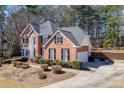 Charming brick home with a large driveway, lush landscaping, and a fenced backyard with a basketball hoop at 395 Highland Gate Cir, Suwanee, GA 30024