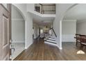 Inviting foyer with hardwood floors, archways, staircase, and views of the living room and dining area at 395 Highland Gate Cir, Suwanee, GA 30024