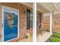 Charming brick home featuring a welcoming blue front door and cozy porch seating at 4037 Hill Station Ct, Sugar Hill, GA 30518