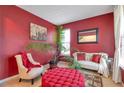 Comfortable living room with vibrant red walls, plush seating, and bright natural light at 4037 Hill Station Ct, Sugar Hill, GA 30518