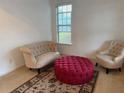 Bright living room featuring neutral seating, a round ottoman, and a window providing natural light at 4037 Hill Station Ct, Sugar Hill, GA 30518