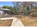 The backyard features a gazebo with outdoor furniture, set amidst a backdrop of mature trees and landscaped garden beds at 4090 Cherry Ridge Walk, Suwanee, GA 30024