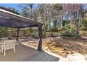 Backyard featuring a cozy gazebo with outdoor furniture, surrounded by mature trees and lush greenery, perfect for relaxation at 4090 Cherry Ridge Walk, Suwanee, GA 30024
