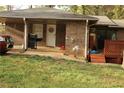 Rear view of brick home with grill, back entrance, and small deck, enhancing outdoor living at 1185 Highway 162, Covington, GA 30016