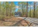 View of two-story home with a two-car garage surrounded by a wooded area at 4453 Autumn Glo Ct Ct, Douglasville, GA 30135