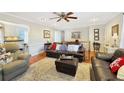 Inviting living room with hardwood floors, neutral paint, large sofa, and an adjacent view of the kitchen at 7440 Banks Mill Rd, Douglasville, GA 30135