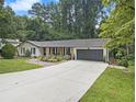 Daytime view of this charming home featuring a well-manicured lawn, and attached two-car garage at 2810 Dunnington Cir, Chamblee, GA 30341