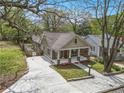 Eye-level view of a well-manicured lawn, concrete driveway, and a home with a welcoming front porch at 559 Robinson Se Ave, Atlanta, GA 30315