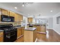 Well-equipped kitchen features wooden cabinets, a kitchen island, and black appliances at 277 Edison Dr, Stockbridge, GA 30281