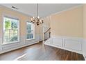 Bright dining room showcasing hardwood floors, classic wainscoting, and natural light from large windows, creating an inviting space at 4461 Kentland Dr, Acworth, GA 30101