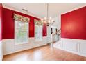 Formal dining room with red walls, chandelier, and natural light at 4461 Kentland Dr, Acworth, GA 30101