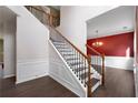 Inviting staircase with hardwood floors, wood railing, and iron spindles leading to the upper level at 4461 Kentland Dr, Acworth, GA 30101