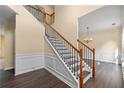 Beautiful staircase featuring wood and iron banisters and stylish wainscoting detail, enhancing the home's elegant entryway at 4461 Kentland Dr, Acworth, GA 30101