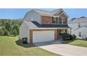 Angle view of brick home with a well-maintained front lawn and attached two car garage at 5675 Laurel Ridge Cir, Atlanta, GA 30344
