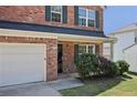 Close up of a charming brick home, manicured bushes, and 2 car garage at 5675 Laurel Ridge Cir, Atlanta, GA 30344