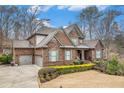 Beautiful brick home with a two-car garage, a well-kept lawn, and tasteful landscaping at 1190 Mosspointe Dr, Roswell, GA 30075