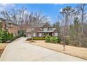 Charming brick home featuring a well-manicured front lawn, mature trees, and a welcoming driveway at 1190 Mosspointe Dr, Roswell, GA 30075