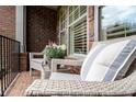 Cozy porch seating area with wicker chairs, providing a relaxing outdoor space with brick flooring at 1190 Mosspointe Dr, Roswell, GA 30075
