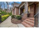 Inviting brick porch with elegant columns, iron railings, and manicured landscaping, offering a warm entrance at 1190 Mosspointe Dr, Roswell, GA 30075