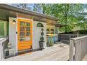 Cozy front porch featuring an eye-catching orange front door and stylish outdoor decor at 952 Columbia Dr, Decatur, GA 30030