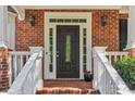 Close-up of a charming brick entryway featuring a black front door with decorative glass panels at 2130 Hollowbrooke Nw Way, Acworth, GA 30101