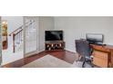 Cozy office space with hardwood floors, a work desk, and a glass door leading to the staircase at 3904 Tristan Way, Suwanee, GA 30024