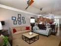 Open living room featuring a ceiling fan, beige sofa, chaise lounge, and kitchen access at 62 Emerson Hill Sq, Marietta, GA 30060